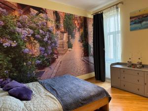 a bedroom with a wall mural of a street at COZY APARTMENT ERNESTA 90m in the city centre - three rooms with balcony in Rīga