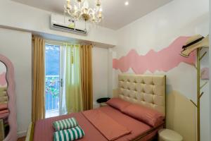 a bedroom with a pink bed and a window at Unique Chiq and comfy place with board games, Quezon City in Manila