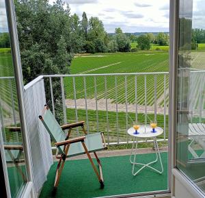 a balcony with a table and two glasses of wine at Le Petit Mouton in Pontorson