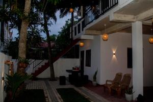 a patio with chairs and a staircase in a house at Double G Motel in Weligama