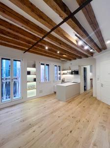 Una gran cocina con paredes blancas y techos de madera. en Ca Ducale 2 min da Piazza San Marco e Palazzo Ducale, en Venecia