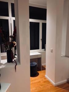 a room with two windows and a table with flowers at Modernes und charmantes City-Apartment im Heusteigviertel Schlosserstraße 30 Stuttgart-Süd in Stuttgart