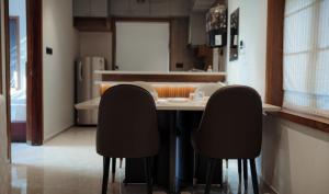 cocina con mesa y 2 sillas negras en French Boulevard, en Mahe