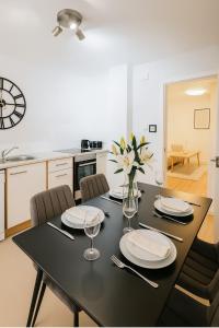アバディーンにあるCharming 1-Bed Home in Aberdeenの黒いダイニングテーブル(椅子付)、花瓶