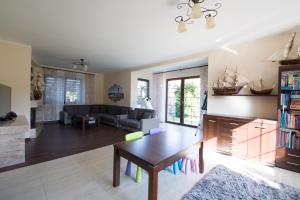 a living room with a table and a couch at Willa Hydrograf in Ustka