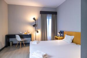 a hotel room with a bed and a desk at Flag Hotel Braga in Braga