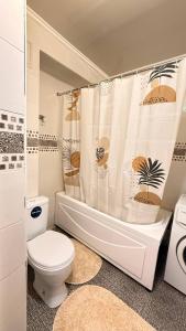 a bathroom with a toilet and a shower curtain at Family apartment comfort in Shymkent