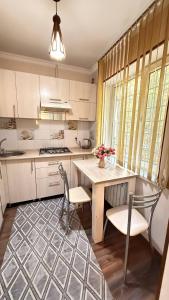 a kitchen with white cabinets and a table and chairs at Family apartment comfort in Shymkent