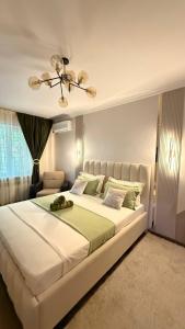 a bedroom with a large white bed with a chandelier at Family apartment comfort in Shymkent +12 photos