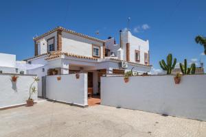 a large white house with a white fence at Casa Mayo con piscina privada in Conil de la Frontera