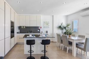 a kitchen and dining room with a table and chairs at Paraná in Quarteira +12 photos