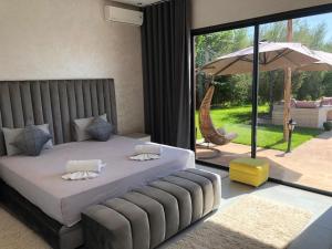 a bedroom with a bed and an umbrella and a patio at Villa privée in Taazout