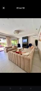 a living room with couches and a flat screen tv at Villa privée in Taazout