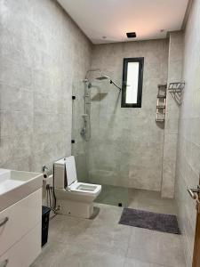 a bathroom with a shower and a toilet and a sink at Villa privée in Taazout