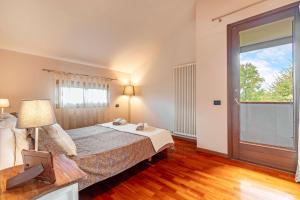 a bedroom with a bed and a large window at Domus Ghirada Terrace in Treviso