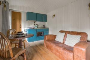 una sala de estar con un sofá y una mesa en Bluebell Lodge, Lake District, en Coniston