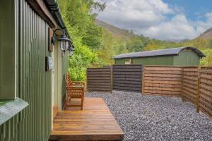 Una pasarela de madera al lado de un edificio con una valla en Bluebell Lodge, Lake District, en Coniston 15 fotos más