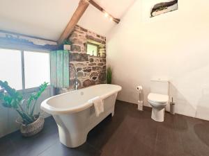 a bathroom with a large bath tub and a toilet at 1 Bed in Newquay oc-c33290 in Saint Columb Major +6 photos