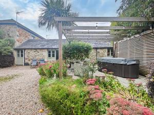 a garden with a wooden pergola in front of a house at 1 Bed in Newquay oc-c33290 in Saint Columb Major