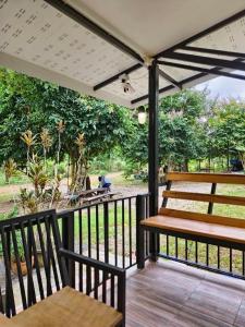 a porch with two benches on a wooden deck at บ้านสามฤดู Baansamruedo in Ban Hin Laem