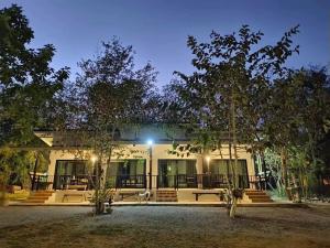 a building with trees in front of it at บ้านสามฤดู Baansamruedo in Ban Hin Laem