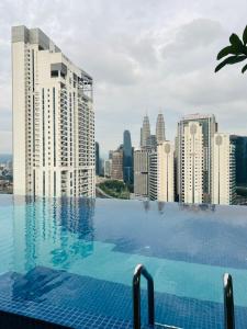 a swimming pool with a view of a city skyline at The Majestic Hospitality near By platinum KLCC in Kuala Lumpur