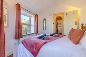 a bedroom with a large white bed with blankets on it at Poppy Cottage in Stiffkey