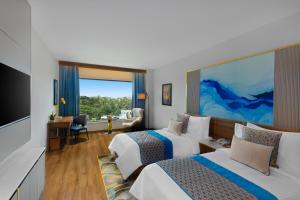 a hotel room with two beds and a flat screen tv at Fortune Airport Road Kochi - Member ITC hotels' group in Cochin