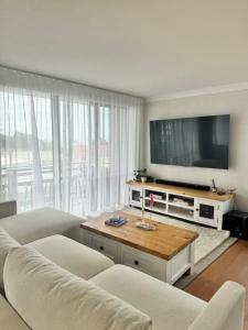 a living room with a couch and a flat screen tv at Rocky Beach unit in Port Macquarie