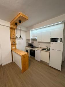 a kitchen with white appliances and a wooden counter top at Apartamentos JM - Sea & Sun in Roquetas de Mar