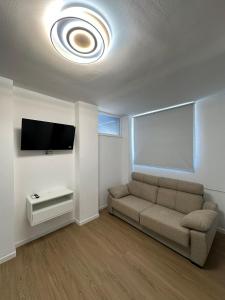 a living room with a couch and a flat screen tv at Apartamentos JM - Sea & Sun in Roquetas de Mar +7 photos