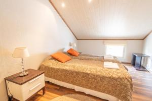 Un dormitorio con una cama y una mesa con una lámpara. en Pajuniemen Uusi Kartano, en Sotkamo