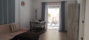a living room with a table and a door to a patio at Carolina Apartments Crete in Agia Pelagia