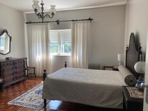 a bedroom with a bed and a dresser and a window at Quinta do Vale Vaqueiro in Sever do Vouga