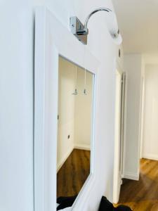 a mirror in a hallway with a light on top at Gorgeous two bedroom luxury Apartment sleeps 6 in Brentwood