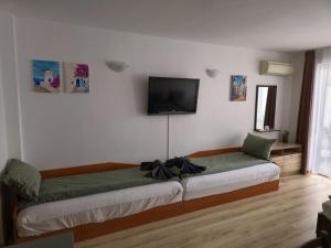 a bedroom with a bed with a television on the wall at Studio Kasandra in Hisarya