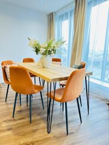 a dining room table with chairs and a vase of flowers at Gorgeous two bedroom luxury Apartment sleeps 6 in Brentwood