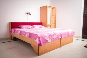 a bedroom with a bed with a pink blanket on it at Hotel Karni Niwas in Jaipur