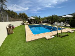 a swimming pool in a yard with green grass at Casa Riondas in Moratalla