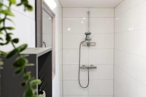 a shower with a shower head in a bathroom at Coastal Family Stay Zoutelande in Zoutelande
