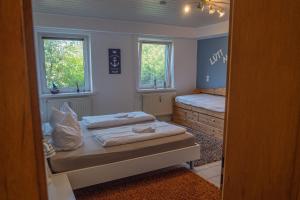a bedroom with two beds and two windows at Haffgeflüster Roggow in Rerik
