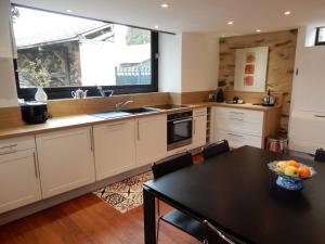 a kitchen with a table and a sink and a window at Le Petit Vigneau in Ménil