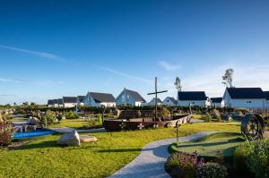 Un jardín con un barco y casas al fondo. en Ferienwohnung LangeBank mit Hafenblick, App 1, Olpenitz, en Olpenitzdorf