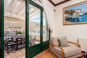 a living room with a chair and a table at Marys Beachfront Villa in Kalymnos