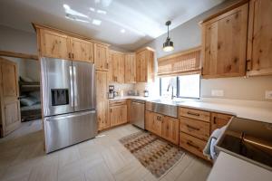 Del NorteにあるModern Home on Rio Grande Riverのキッチン(木製キャビネット、ステンレス製の冷蔵庫付)
