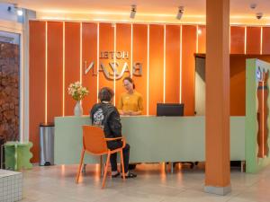 ダラットにあるBazan Dalat Hotelのロビーの机に座る者