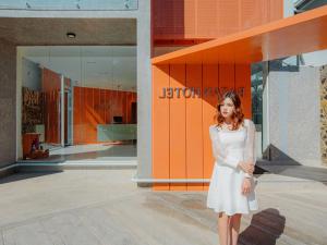 a woman in a white dress standing in front of a building at Bazan Dalat Hotel in Da Lat