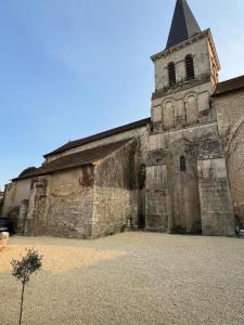 an old church with a steeple on top of it at Il Clovio - Discreet luxury, close to Futuroscope in Jaunay-Marigny
