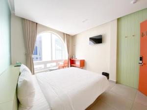 a bedroom with a white bed and a window at Bazan Dalat Hotel in Da Lat