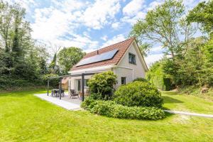 a small white house with a patio in the yard at Doggersbank 16 - Noordzeepark Ouddorp in Ouddorp